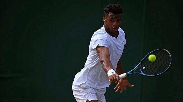 La raquette semble minuscule dans les 6'8" La main du Français.