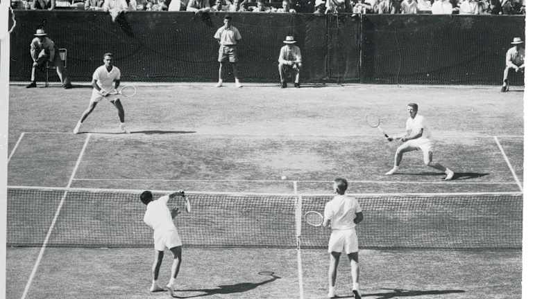 Vic Seixas (à gauche, au fond du court) et Tony Trabert affrontent Ken Rosewall (à gauche, à proximité du court) et Lew Hoad en double de la Coupe Davis au White City Stadium de Sydney, en Australie. Grâce à leur victoire finale, les Américains ont remporté la rencontre et ramené la Coupe aux États-Unis après cinq ans de disette.