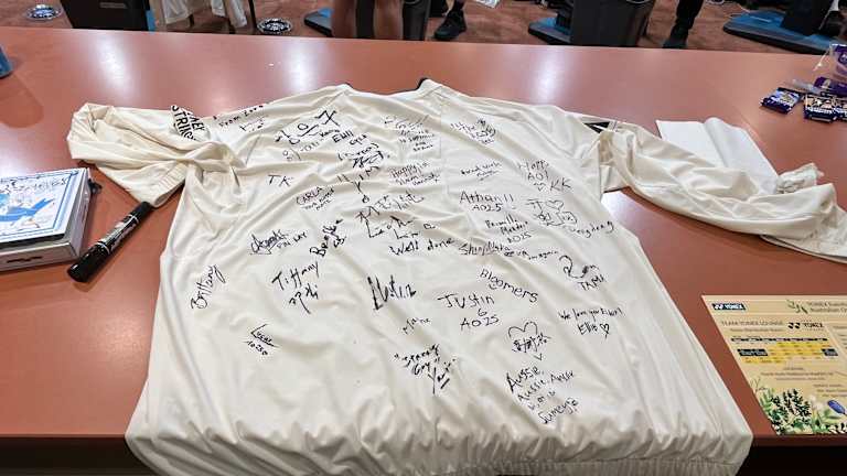 Les signatures du personnel de la salle de cordage ornent un T-shirt commémoratif.