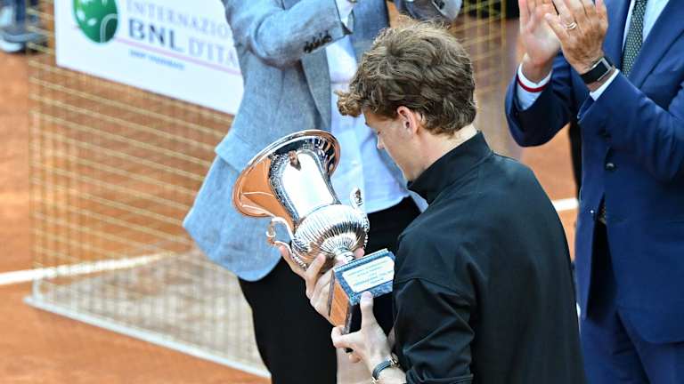 Sinner examine le trophée, après avoir été félicité sur scène par le président italien Sergio Mattarella et le champion de 1976 Adriano Panatta.